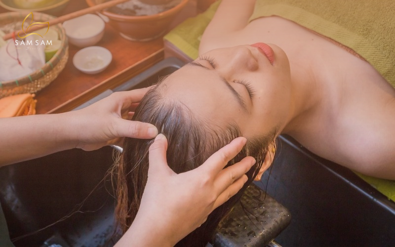 Kỹ thuật viên thực hiện quy trình gội đầu dưỡng sinh thảo dược tại Sam Sam