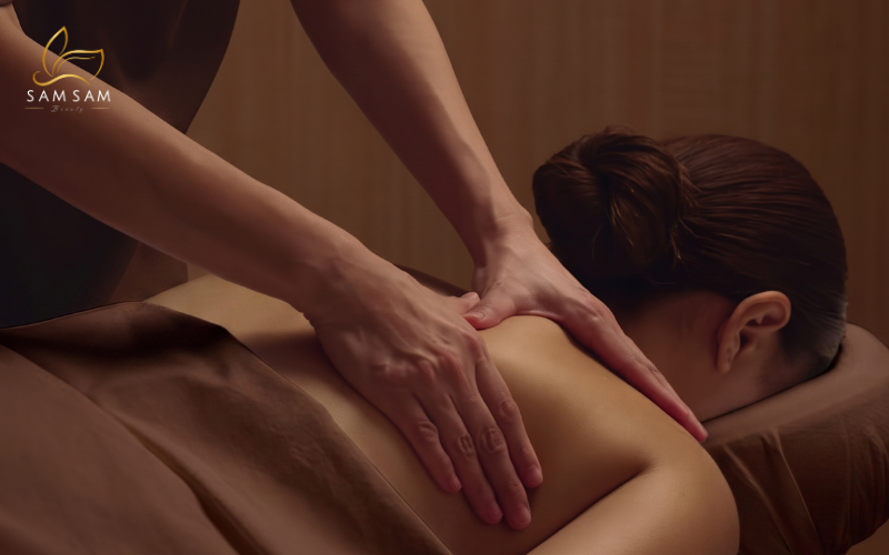 Therapist applying light directional strokes during a manual lymphatic drainage session in Saigon.